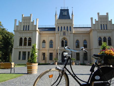 Außenansicht vom Schloss Evenburg bei blauem Himmel mit Fahrrad im Vordergrund
